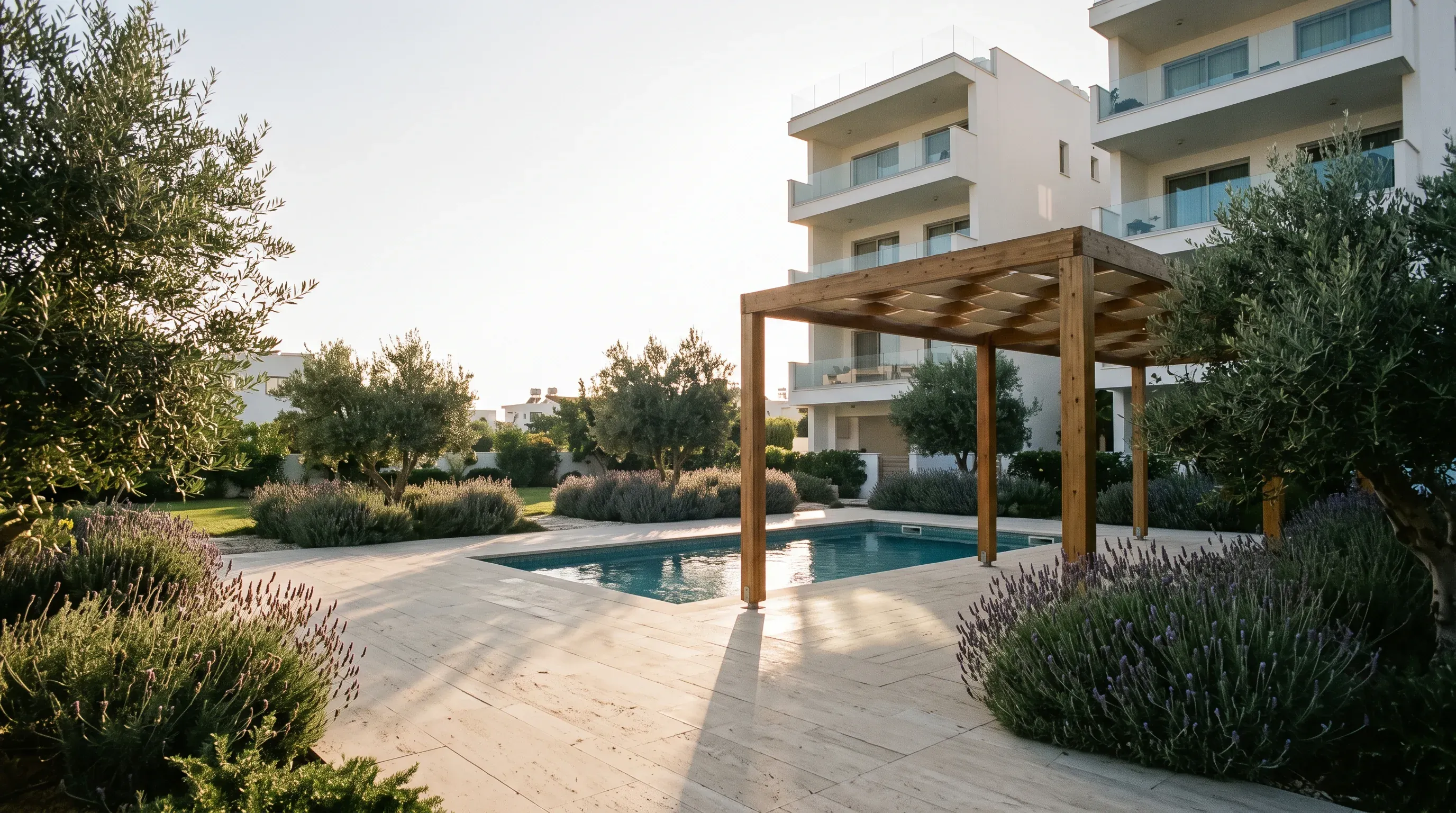 A garden with a pool under a pergola, apartment blocks behind